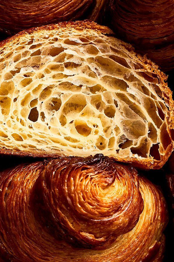 Close-up of a baked croissant showing its open honeycomb layers